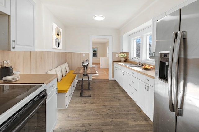 kitchen featuring white cabinetry, sink, electric range, stainless steel fridge with ice dispenser, and dark wood-type flooring