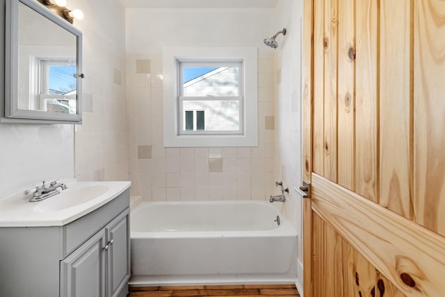 bathroom with vanity, tiled shower / bath combo, and a wealth of natural light