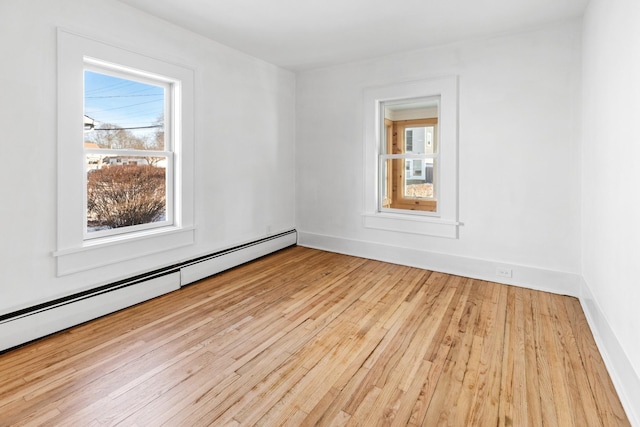 empty room featuring a baseboard radiator and light wood-type flooring