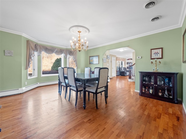 11 Balanchine Ct, Airmont, NY 10952 - dining room with arched walkways, a chandelier, crown molding, wood finished floors, and baseboards