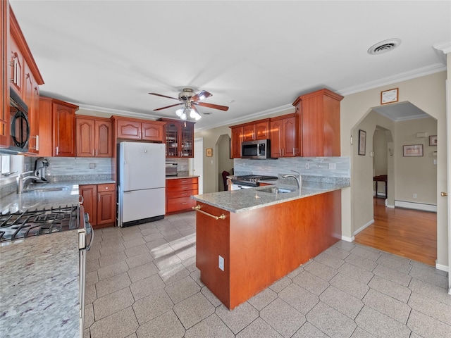 11 Balanchine Ct, Airmont, NY 10952 - kitchen featuring stainless steel appliances, arched walkways, a ceiling fan, ornamental molding, and decorative backsplash