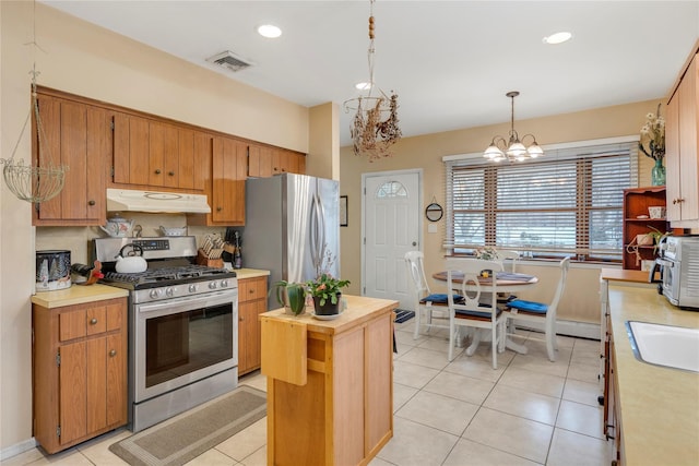 kitchen with decorative light fixtures, light tile patterned floors, appliances with stainless steel finishes, and a notable chandelier