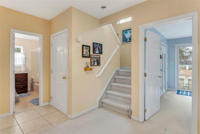 staircase with plenty of natural light and carpet flooring