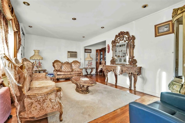 living room with a wall mounted air conditioner and hardwood / wood-style floors