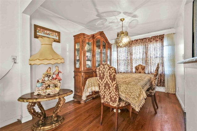 dining area featuring a notable chandelier, dark hardwood / wood-style flooring, and ornamental molding