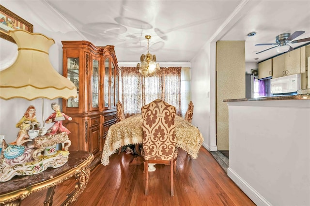 dining area featuring wood-type flooring, ceiling fan, and crown molding