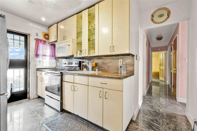 kitchen featuring stainless steel electric stove, backsplash, and sink