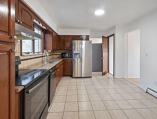 kitchen featuring black appliances, decorative backsplash, light tile patterned flooring, and sink