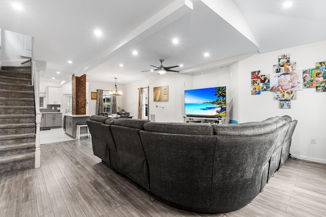 living room with ceiling fan with notable chandelier