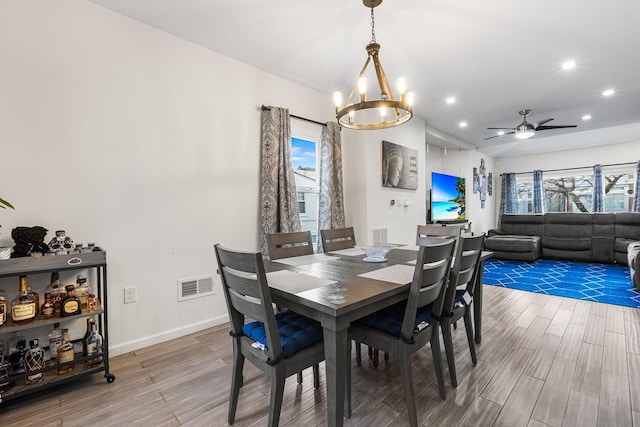 dining area with ceiling fan with notable chandelier and a healthy amount of sunlight