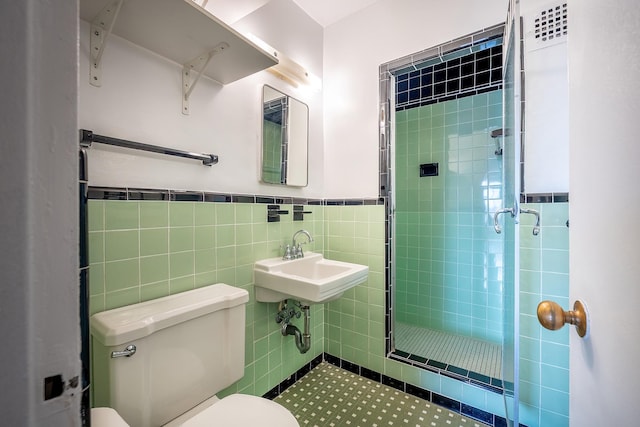2727 Palisade Ave Unit 16Ab, Bronx, NY 10463 - bathroom with toilet, a shower stall, a sink, a wainscoted wall, and tile walls