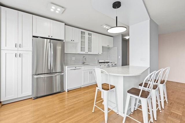 2727 Palisade Ave Unit 16Ab, Bronx, NY 10463 - kitchen with white appliances, a breakfast bar area, glass insert cabinets, a sink, and decorative backsplash
