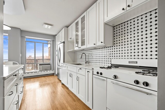 2727 Palisade Ave Unit 16Ab, Bronx, NY 10463 - kitchen with white appliances, a sink, light countertops, white cabinets, and glass insert cabinets