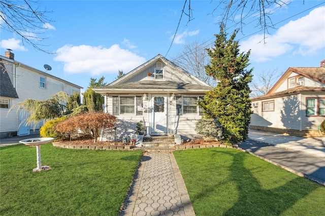 bungalow-style home featuring a front lawn