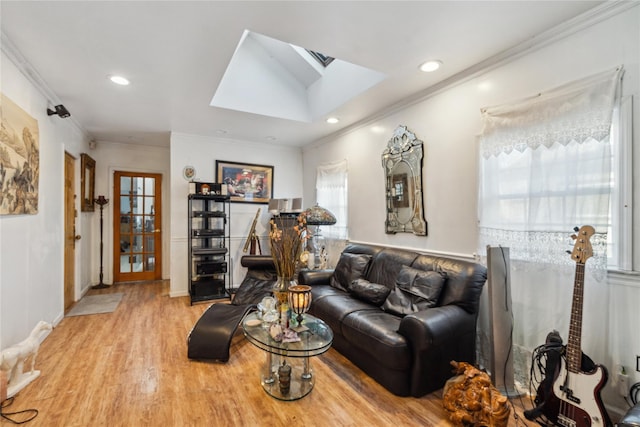 living room featuring hardwood / wood-style flooring, crown molding, and a skylight