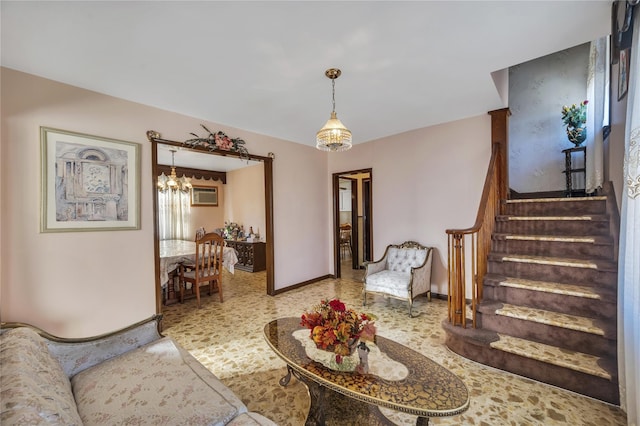 living room with a wall mounted air conditioner and an inviting chandelier