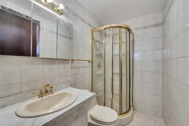 bathroom with a shower with door, toilet, tile walls, and sink