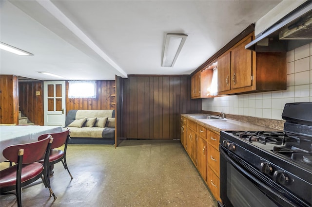 kitchen featuring black range with gas stovetop, ventilation hood, and sink