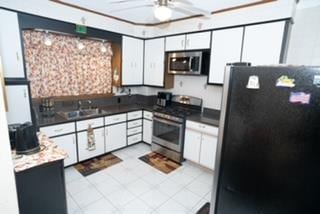 kitchen with ceiling fan, sink, white cabinets, and appliances with stainless steel finishes