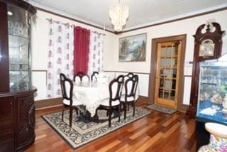 dining space with dark hardwood / wood-style floors and an inviting chandelier