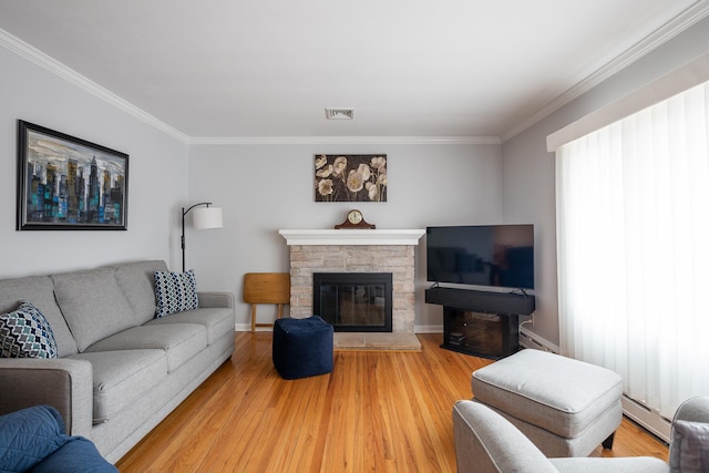 living room with ornamental molding, a fireplace, wood-type flooring, and a baseboard radiator