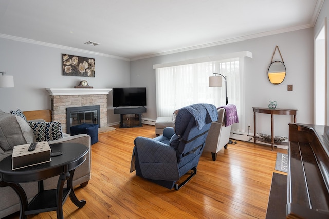 living room with baseboard heating, ornamental molding, a fireplace, and wood-type flooring