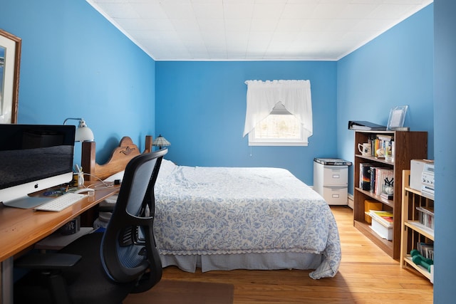 bedroom featuring crown molding and light wood-type flooring