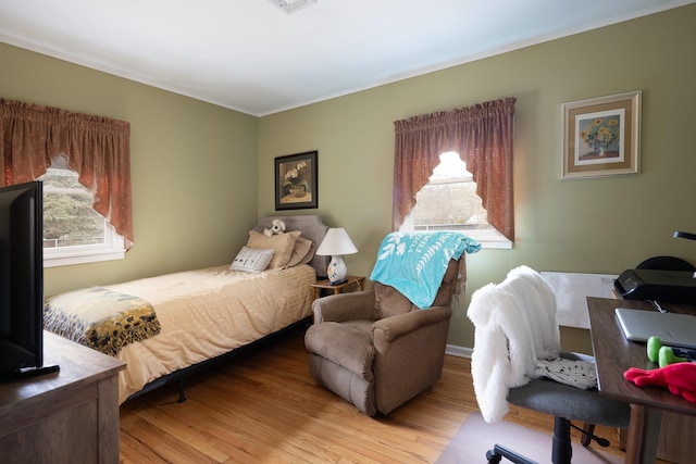 bedroom with multiple windows and light hardwood / wood-style flooring