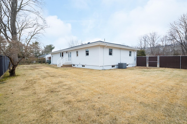 rear view of property featuring central AC and a yard