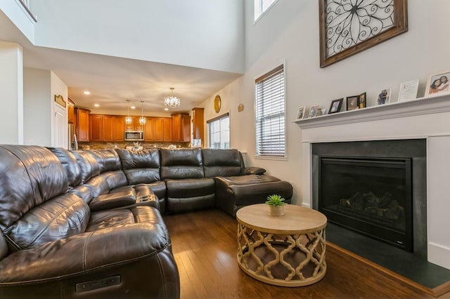 living room featuring a notable chandelier and dark hardwood / wood-style flooring