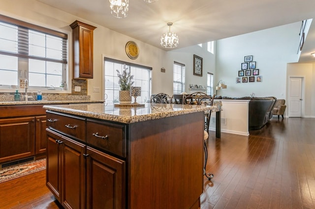 kitchen with a kitchen island, a notable chandelier, dark hardwood / wood-style floors, and hanging light fixtures