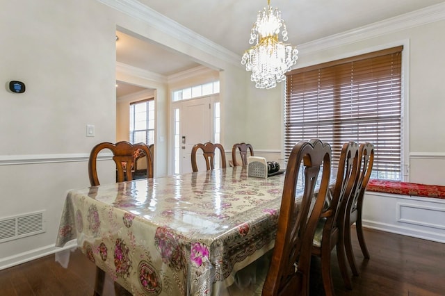 dining space with a notable chandelier, crown molding, and dark hardwood / wood-style floors