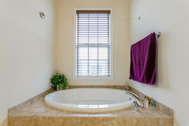 bathroom with tiled tub and plenty of natural light