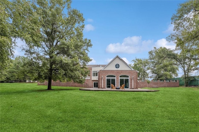 back of property with a lawn and a patio