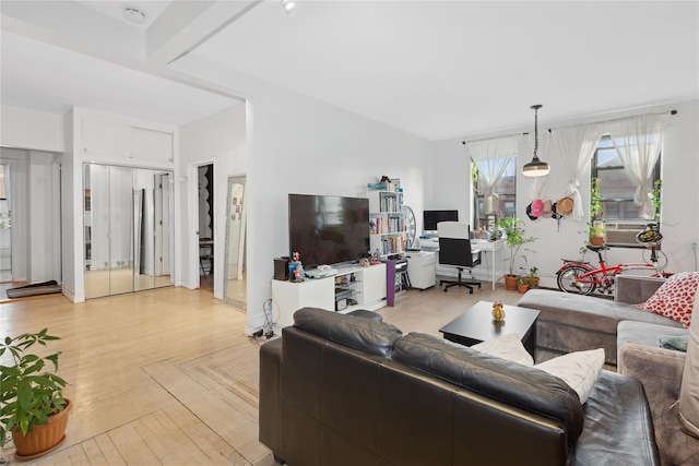 living room featuring beamed ceiling and light parquet flooring