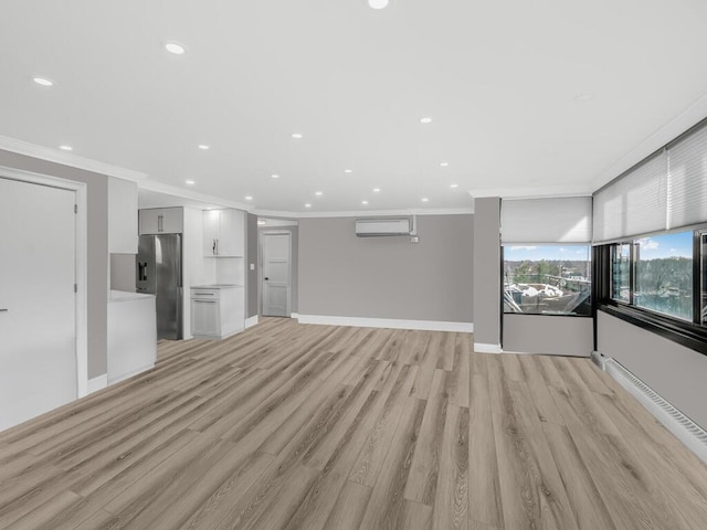 unfurnished living room with light hardwood / wood-style floors, an AC wall unit, and ornamental molding