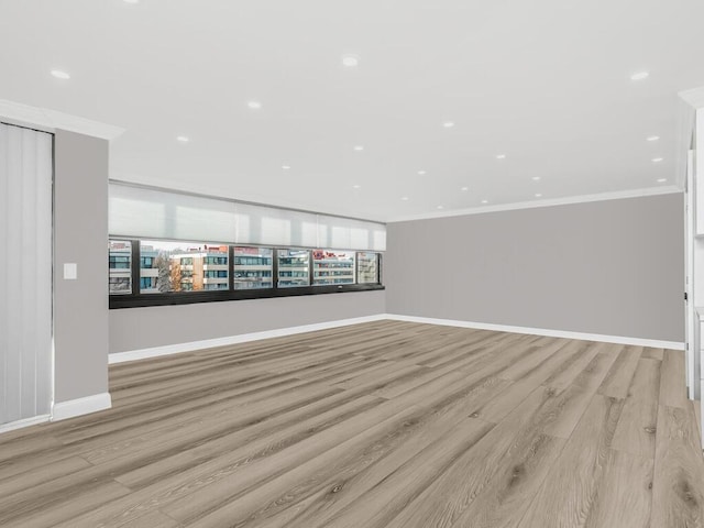 empty room with light hardwood / wood-style flooring and crown molding