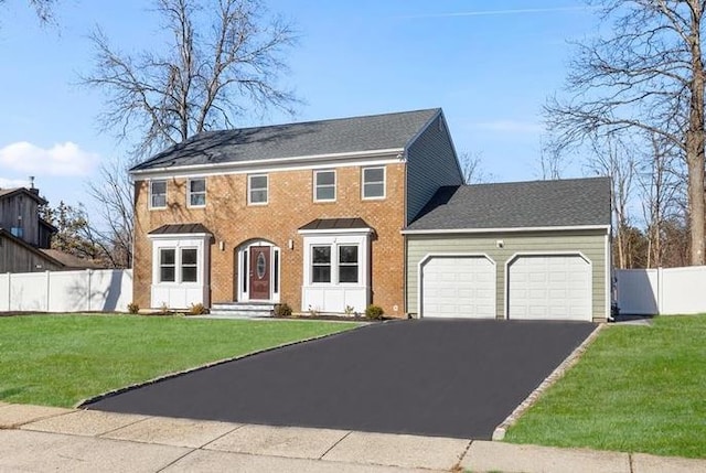 colonial-style house with a front yard and a garage