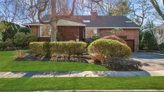 view of front of home with a garage and a front lawn