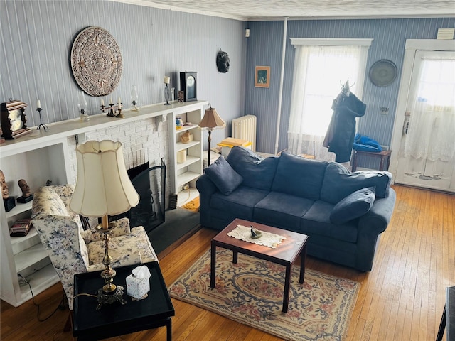 living room featuring a fireplace, hardwood / wood-style floors, and radiator