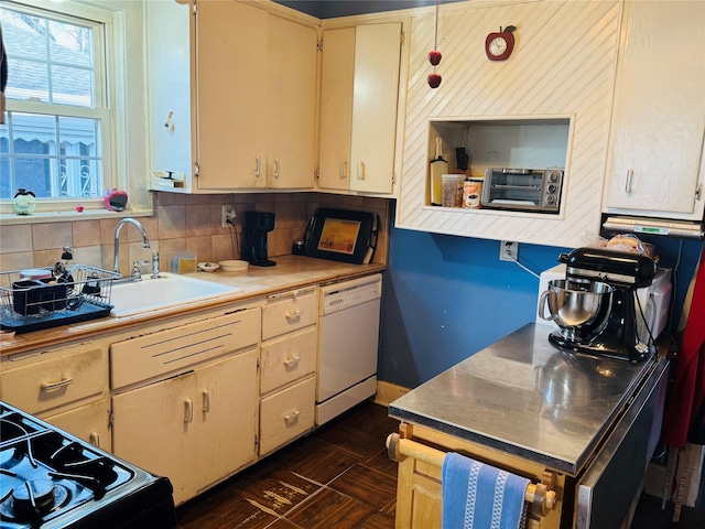 kitchen with white dishwasher, backsplash, stove, and sink