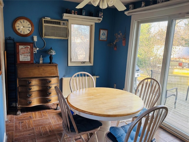 dining space featuring ceiling fan and an AC wall unit