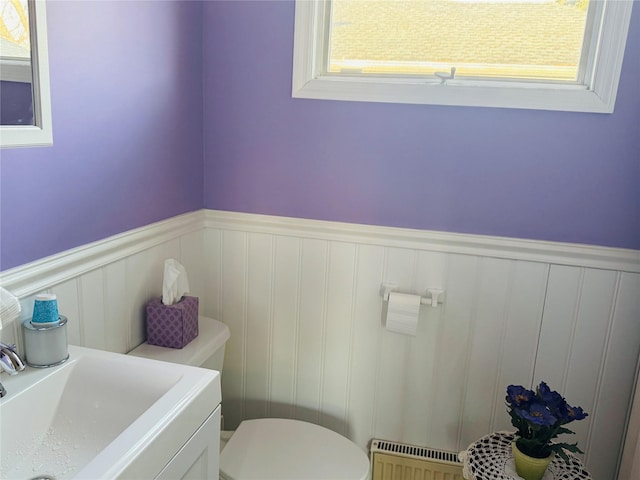 bathroom featuring toilet, radiator, and sink