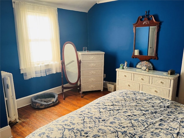 bedroom featuring radiator heating unit and hardwood / wood-style floors