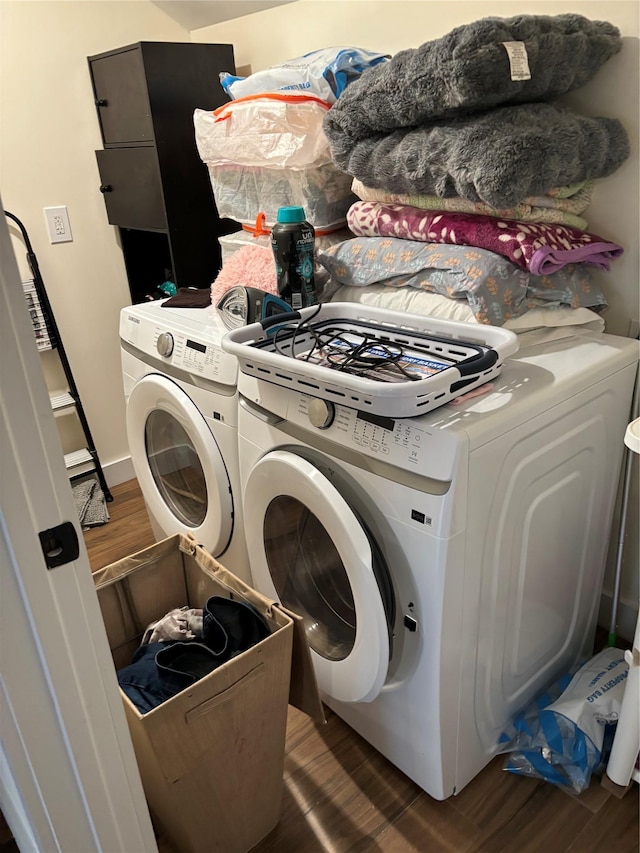 clothes washing area with washer and dryer and dark wood-type flooring