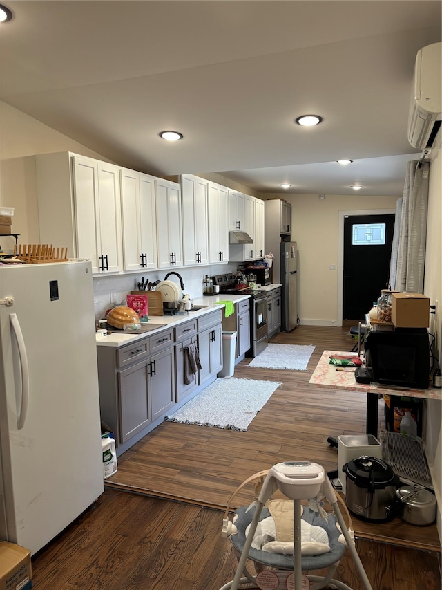 kitchen featuring sink, stainless steel appliances, tasteful backsplash, dark hardwood / wood-style floors, and white cabinets