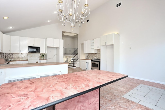 kitchen with white cabinets, decorative backsplash, high vaulted ceiling, and hanging light fixtures