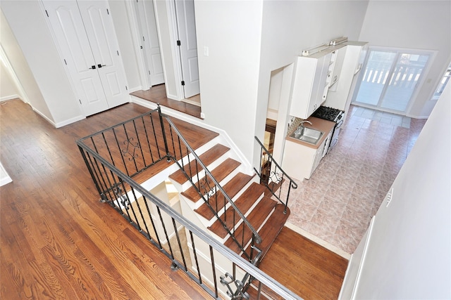 staircase featuring hardwood / wood-style flooring and sink