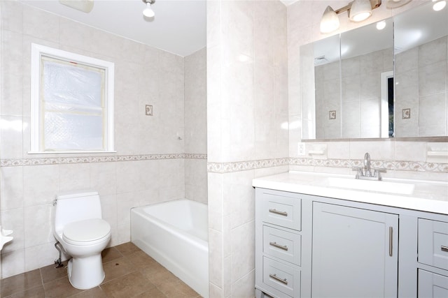 bathroom featuring tile patterned floors, vanity, toilet, and tile walls