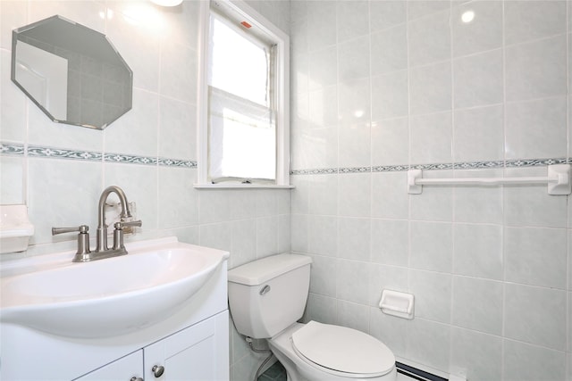 bathroom with vanity, a baseboard radiator, toilet, and tile walls